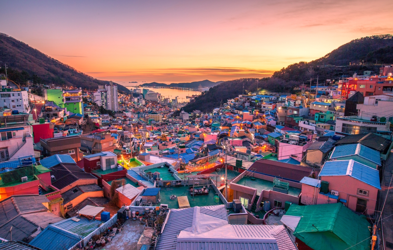 Discover the charm of colorful houses cascading down the hillside with the ocean in the background creating a picturesque scene that invites exploration and adventure in Busan's unique setting.